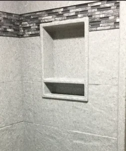 A bathroom with a white shower and tiled walls.